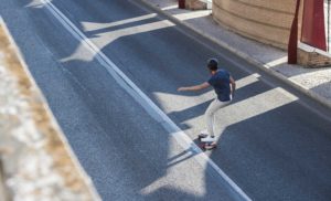 electric longboarder turning on streets