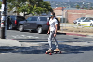 a commuter riding a budget electric longboard